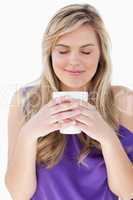 Young woman smelling her cup of coffee