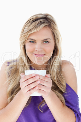 Young blonde woman holding a cup of coffee
