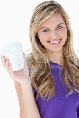 Smiling blonde woman holding a cup of coffee