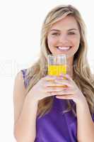 Smiling blonde woman holding an orange juice