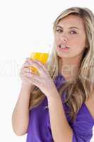 Attractive blonde woman holding an orange juice