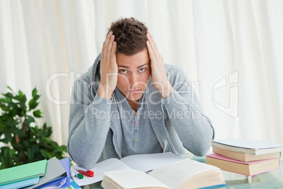 Portrait of a distressed student doing his homeworks