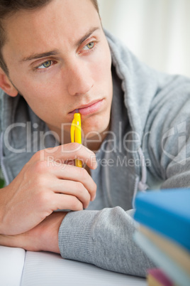 Close-up of a depressed student chewing his pencil