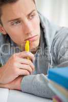 Close-up of a depressed student chewing his pencil