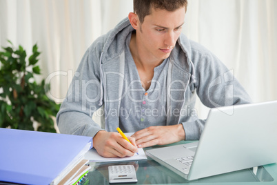 Student doing his homework with a laptop