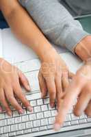 High view of students hands working with a laptop