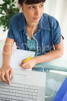 Female student looking away while doing her homework