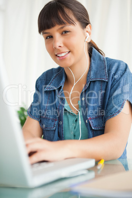 Portrait of a female student doing her homework with music