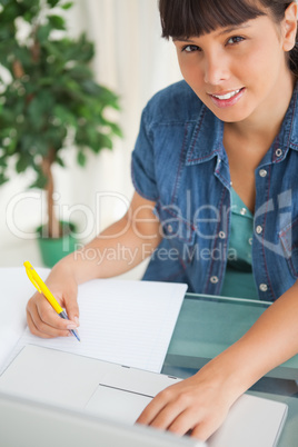 Portrait of a cute smiling student doing her homework