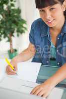 Portrait of a cute smiling student doing her homework