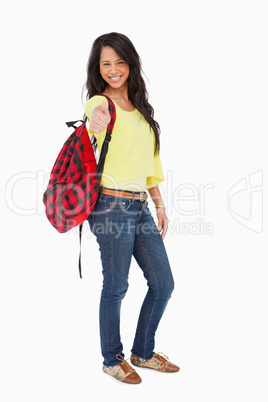 Smiling Latin student thumb-up with a backpack