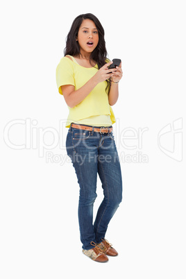 Portrait of a Latin student surprised while using a smartphone