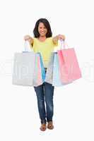 Beautiful Latin student showing her shopping bags