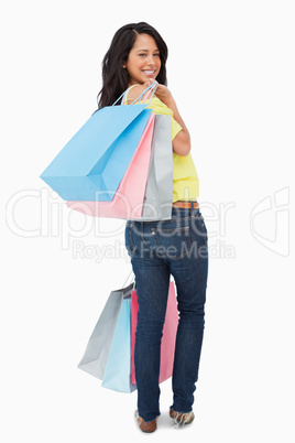 Rear view of a beautiful Latin student with shopping bags