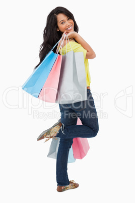 Rear view of a happy Latin student with shopping bags
