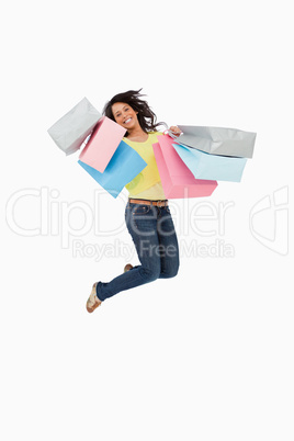Latin student jumping with shopping bags
