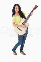 Young Latino woman holding a guitar