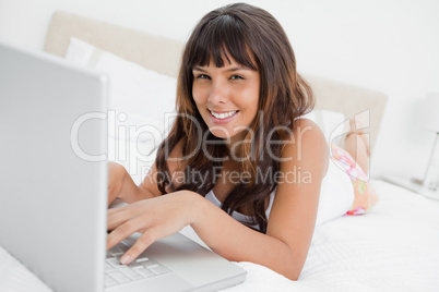 Portrait of a woman in pajama chatting on a laptop