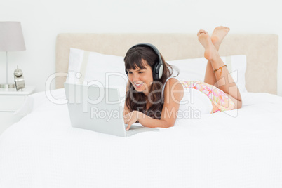 Young woman chatting on a laptop with earphones