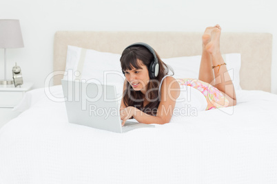 Young woman chatting with a laptop with earphones