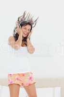 Student in pajama listing to music while jumping