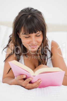 Smiling young woman reading a book