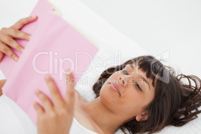 Angle shot of a young woman reading a book