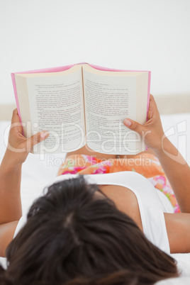 Rear view of a young woman reading a novel