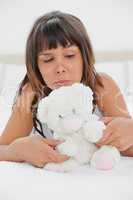 Grimacing young woman playing with a teddy bear