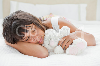 Young woman sleeping with a teddy bear