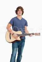 Male student posing while holding a guitar