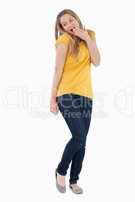 Surprised young woman hands in front of her mouth