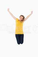 Young woman in yellow shirt jumping while raising arms