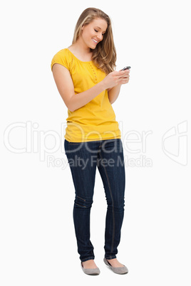 Attractive blonde woman smiling while using her cellphone