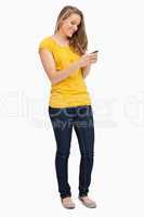 Attractive blonde woman smiling while using her cellphone