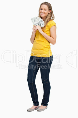 Blonde woman smiling while holding a lot of dollars