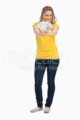 Blonde woman smiling while showing a lot of dollars
