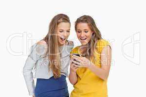Two voiceless young women looking a smartphone