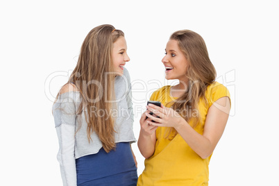 Two happy young women looking a smartphone