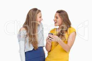 Two happy young women looking a smartphone