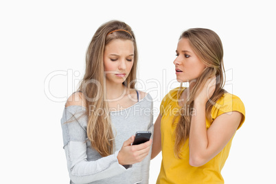 Upset young woman consoled by her friend