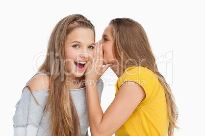 Blonde student whispering to her friend