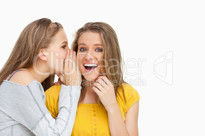 Blonde student whispering to a friend