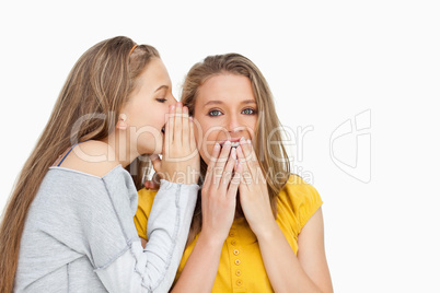 Blonde student whispering to her voiceless friend