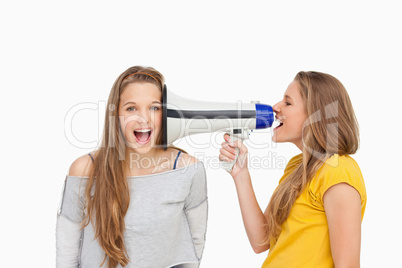 Blonde student using a loudspeaker on her friend