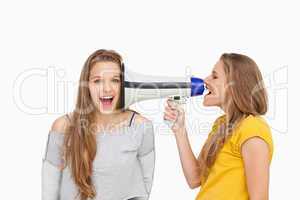 Blonde student using a loudspeaker on her friend