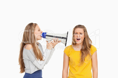 Female student using a loudspeaker on a other girl