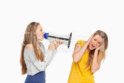 Blonde student yelling with a loudspeaker on a other girl