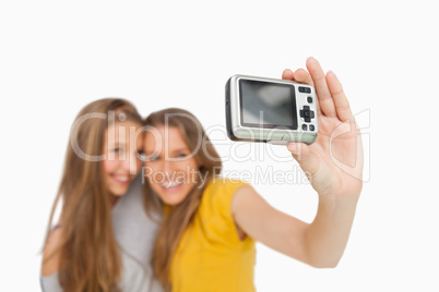 Two students taking a picture of themselves with a digital camer