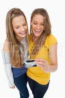 Two friends laughing while checking their picture on a digital c